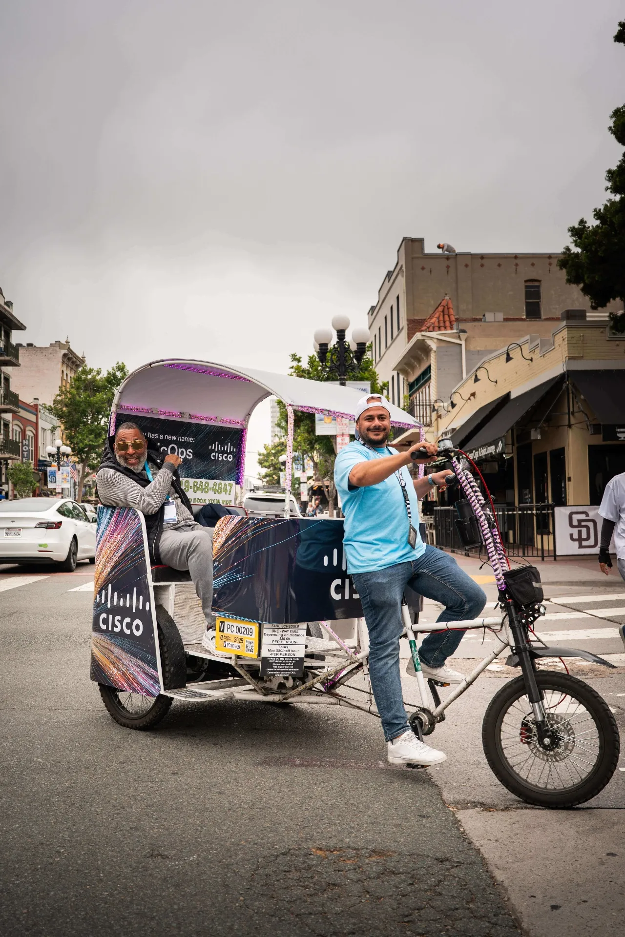Cisco branded pedicab carrying a passenger through San Diego's Gaslamp Quarter as branded transportation
