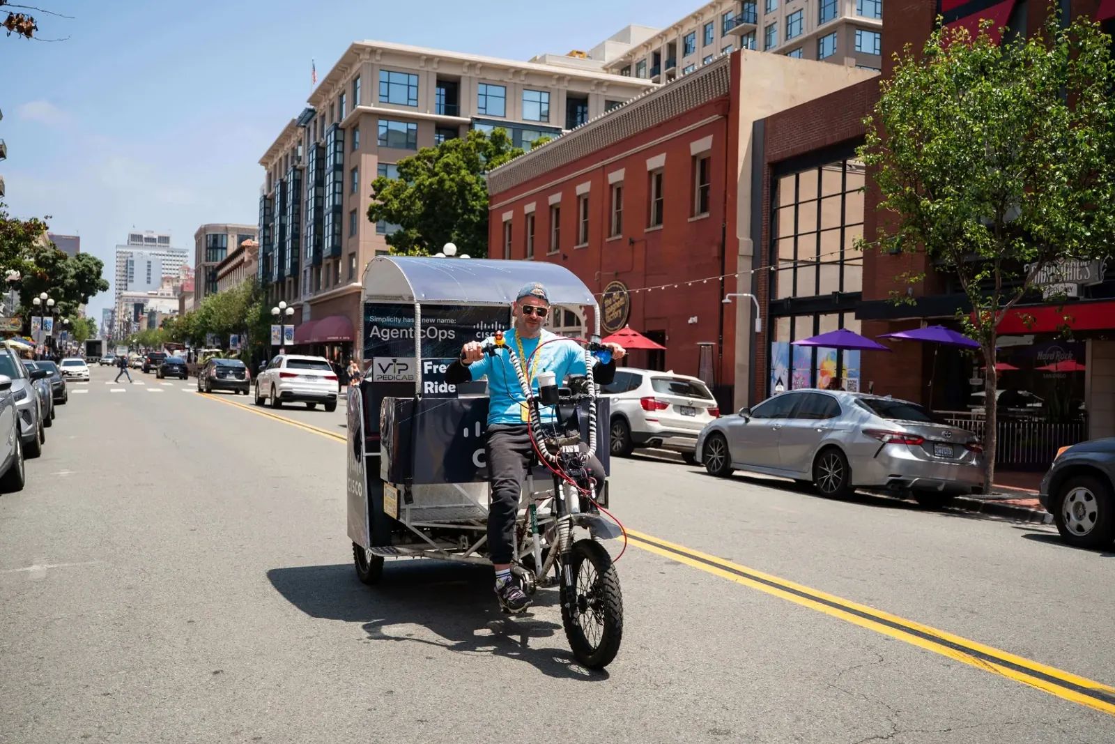 VIP Pedicab driver with Cisco advertising riding through downtown San Diego